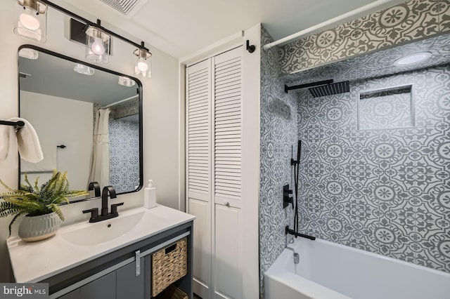 bathroom with vanity, shower / bath combination with curtain, visible vents, and a closet