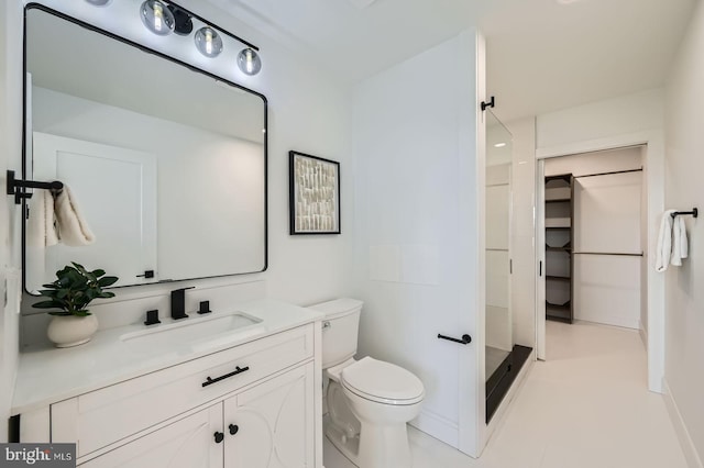 full bath with walk in shower, toilet, a spacious closet, and vanity