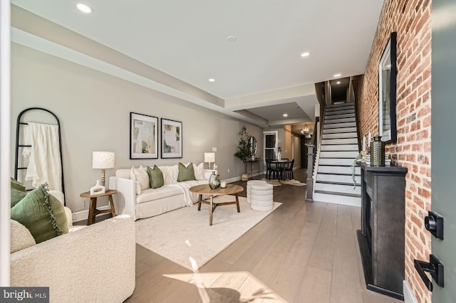 living room featuring recessed lighting, baseboards, wood-type flooring, and stairs