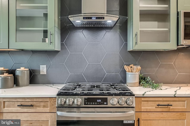 kitchen featuring glass insert cabinets, ventilation hood, green cabinets, and stainless steel appliances