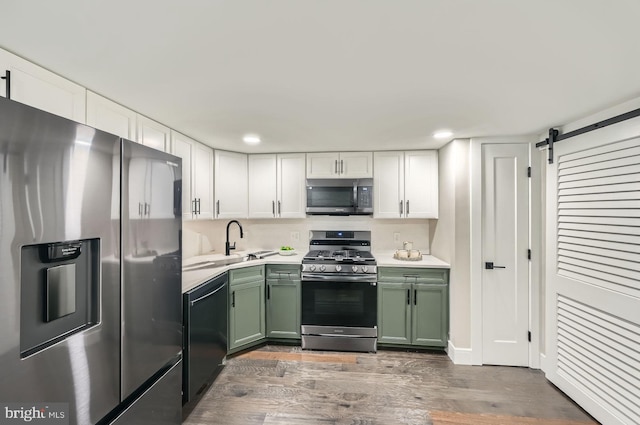 kitchen featuring a barn door, appliances with stainless steel finishes, green cabinets, white cabinets, and light countertops