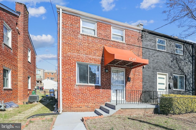 townhome / multi-family property with central air condition unit and brick siding