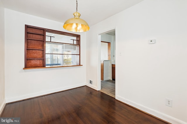 unfurnished dining area featuring dark wood-type flooring, visible vents, and baseboards