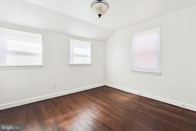 unfurnished room with baseboards, lofted ceiling, and hardwood / wood-style flooring