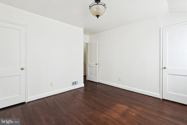 unfurnished bedroom with baseboards, visible vents, and dark wood-style flooring