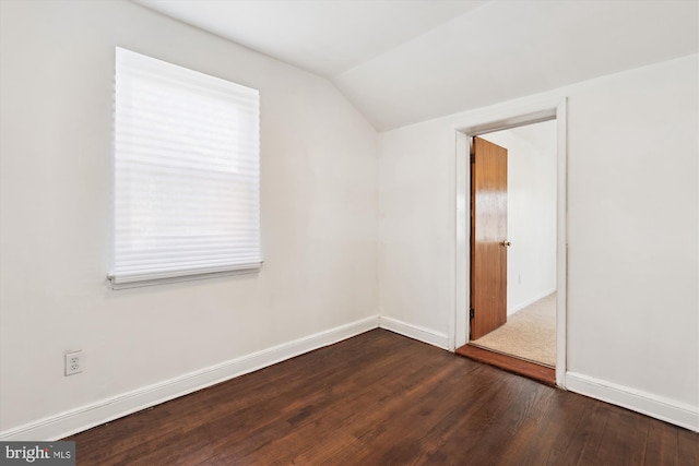 empty room with baseboards, lofted ceiling, and hardwood / wood-style flooring