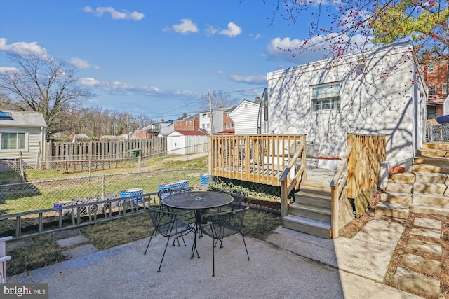 view of patio with a deck, an outdoor structure, outdoor dining area, and fence