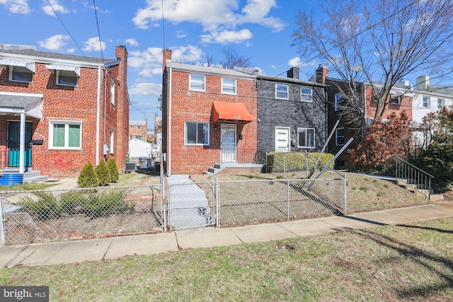 townhome / multi-family property featuring brick siding, a chimney, a fenced front yard, and a gate