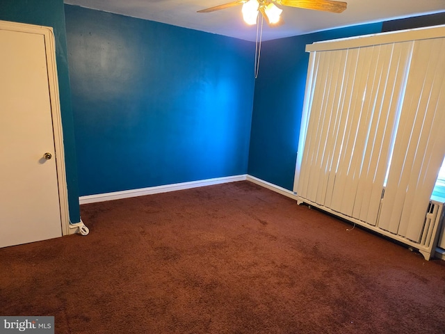 empty room with carpet flooring, a ceiling fan, and baseboards