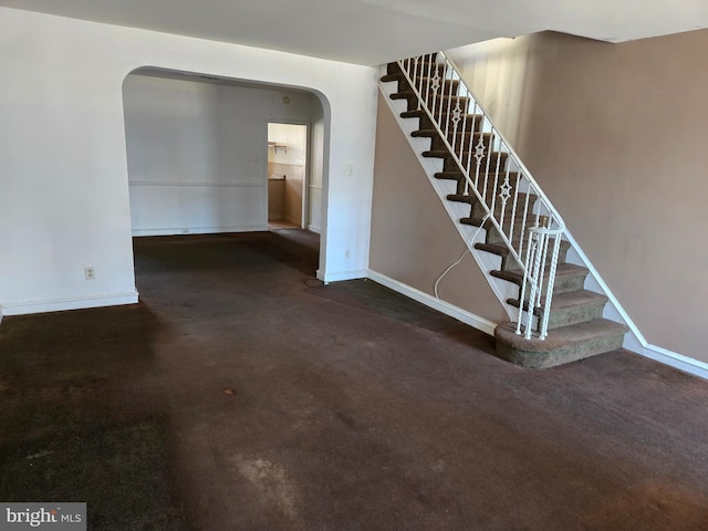 interior space featuring arched walkways and baseboards