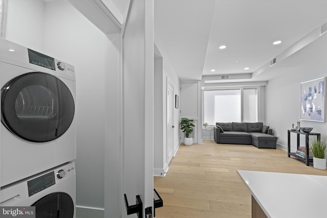 clothes washing area with visible vents, laundry area, recessed lighting, stacked washer and dryer, and light wood-style floors