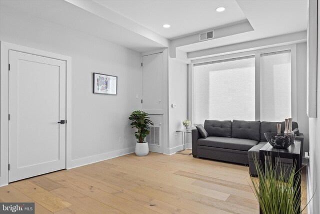 living area with recessed lighting, visible vents, baseboards, and light wood finished floors