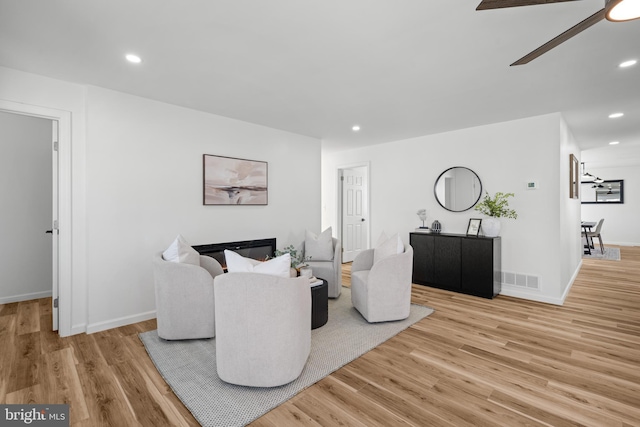 living room featuring light wood finished floors, visible vents, recessed lighting, and a ceiling fan