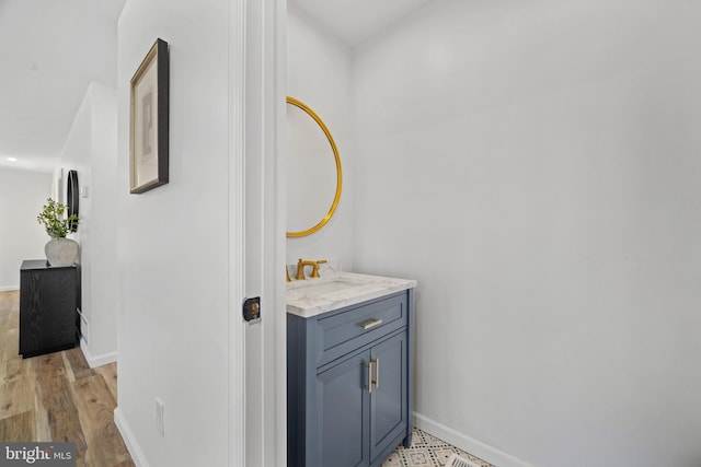 bathroom with vanity, baseboards, and wood finished floors