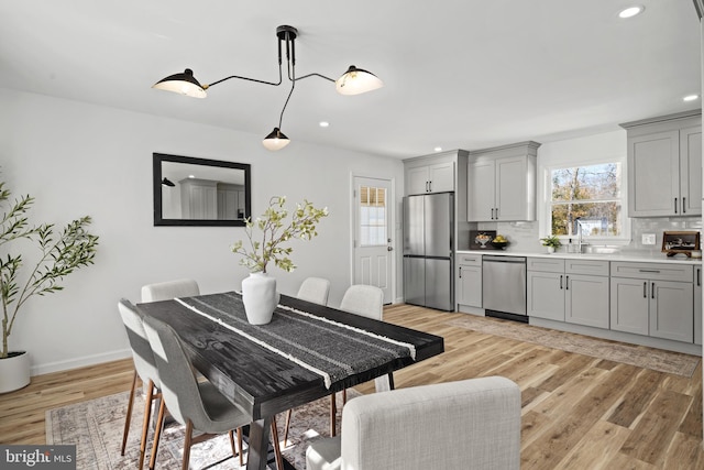 dining room featuring recessed lighting, baseboards, and light wood-style floors