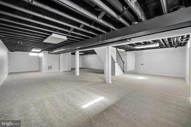 basement with stairs, visible vents, and carpet floors