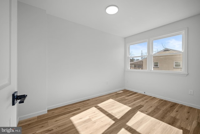 unfurnished room with baseboards and wood finished floors