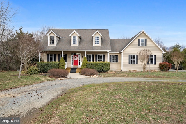 cape cod house featuring a shingled roof and a front yard