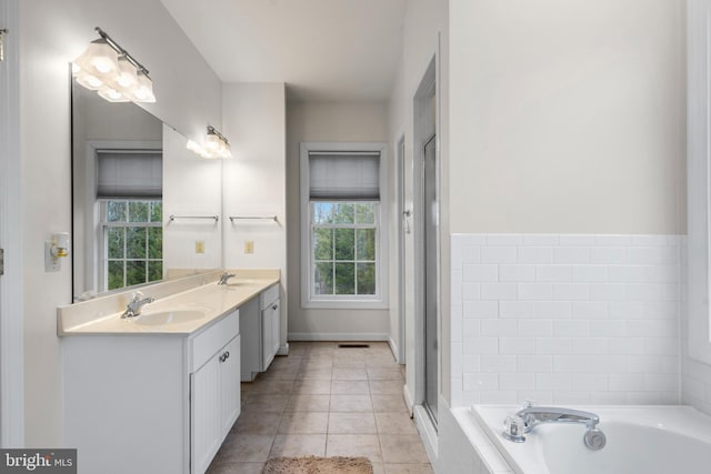 bathroom with a sink, a bath, double vanity, and tile patterned floors