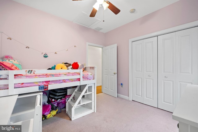 carpeted bedroom featuring attic access, a closet, and ceiling fan