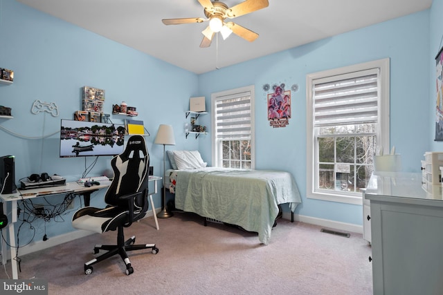 carpeted bedroom with a ceiling fan, baseboards, and visible vents