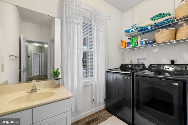 laundry area featuring baseboards, separate washer and dryer, visible vents, and a sink