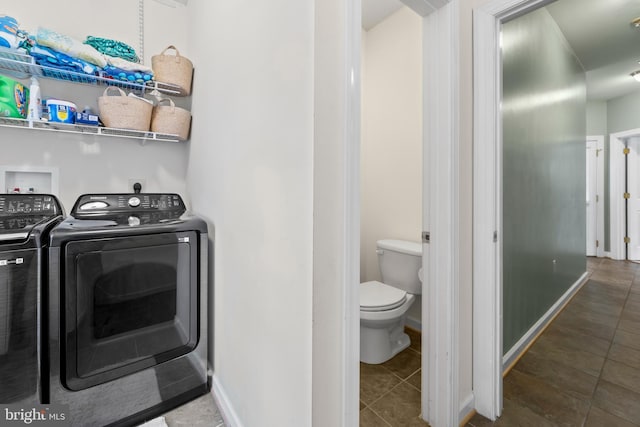 laundry room featuring tile patterned flooring, laundry area, washing machine and dryer, and baseboards