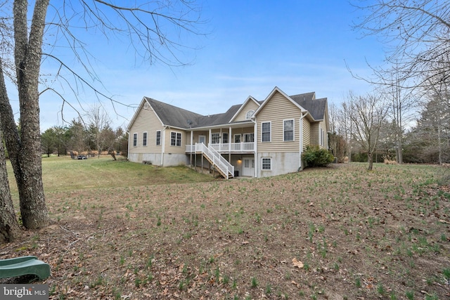 view of front of house featuring stairs and a lawn