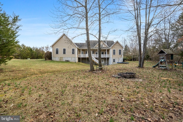 view of front of house with stairs, a fire pit, a front lawn, and a playground