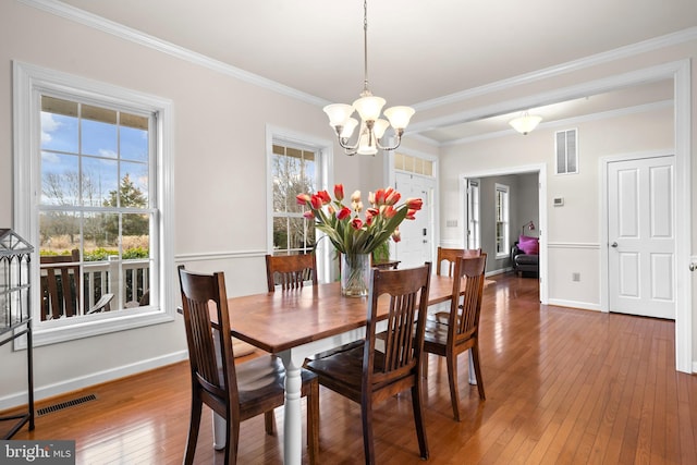 dining room with baseboards, visible vents, wood-type flooring, and an inviting chandelier