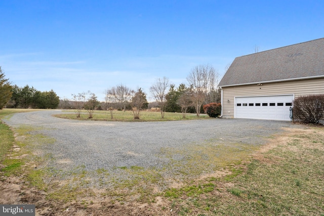 view of yard with driveway and a garage