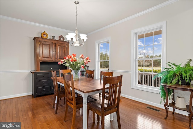 dining space featuring a notable chandelier, baseboards, and wood-type flooring