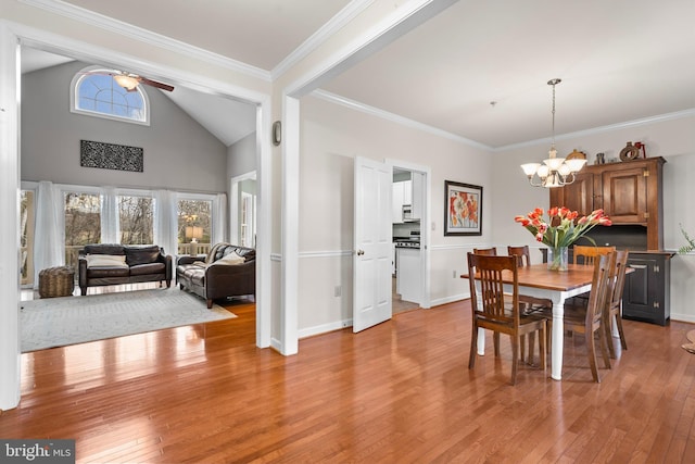 dining room with light wood-style floors, ornamental molding, and ceiling fan with notable chandelier