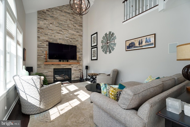 living room with a large fireplace, high vaulted ceiling, and a healthy amount of sunlight