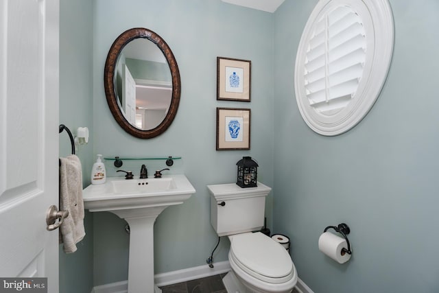 bathroom with toilet and baseboards