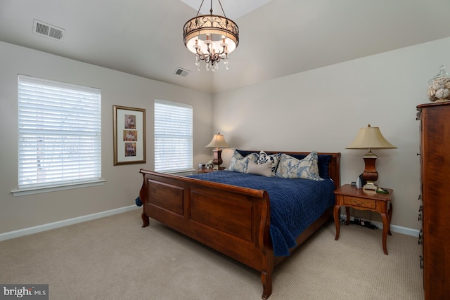 bedroom with light colored carpet, visible vents, and a chandelier