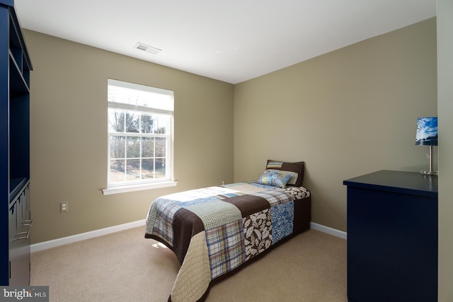 bedroom featuring visible vents, light carpet, and baseboards