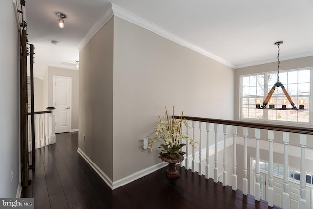 hall featuring dark wood-style floors, baseboards, a notable chandelier, and ornamental molding