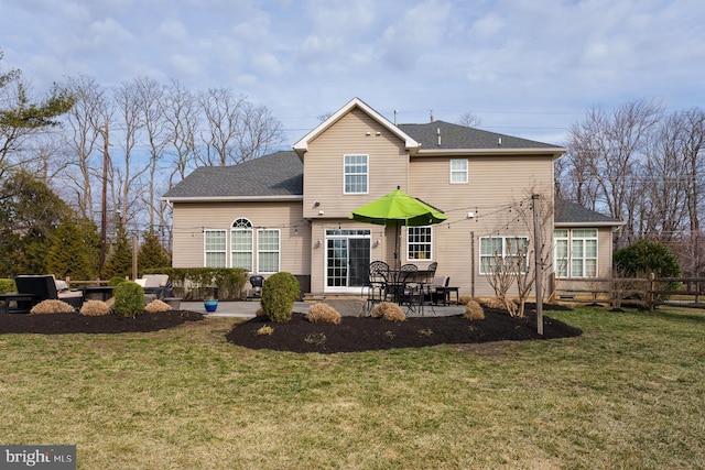 rear view of house with a lawn, an outdoor fire pit, a patio, and fence