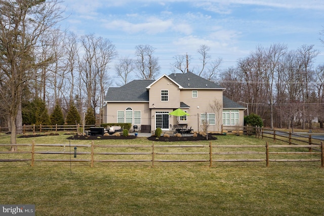 rear view of house with a patio area, a lawn, roof with shingles, and fence private yard