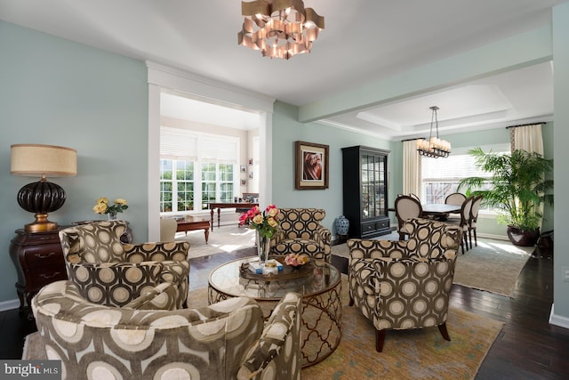 interior space featuring a notable chandelier, a raised ceiling, baseboards, and wood-type flooring