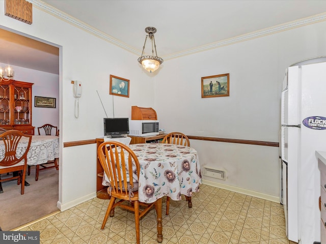 dining room featuring an inviting chandelier, baseboards, and ornamental molding