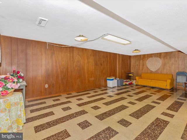 unfurnished room featuring wood walls