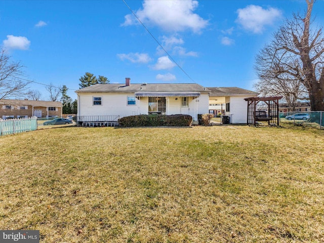 back of property featuring fence and a lawn