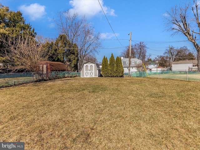 view of yard featuring a storage shed, an outdoor structure, and fence