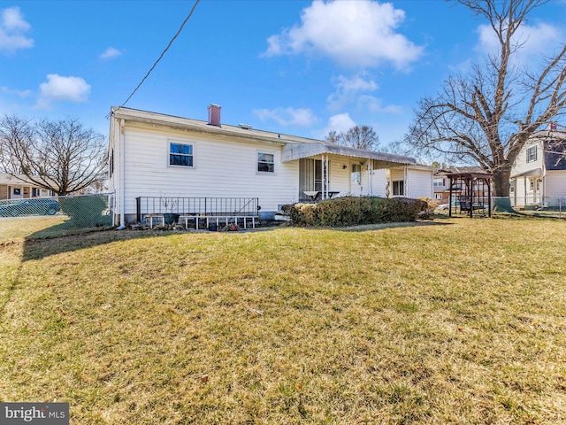 rear view of house with fence, a yard, covered porch, a chimney, and a playground