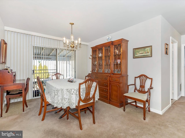 dining room with light colored carpet, baseboards, and a notable chandelier