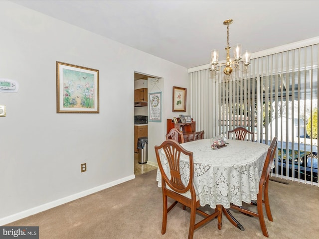 dining space with an inviting chandelier, light colored carpet, and baseboards