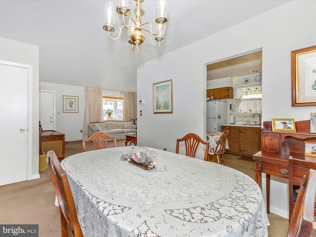 dining area with light carpet and a chandelier