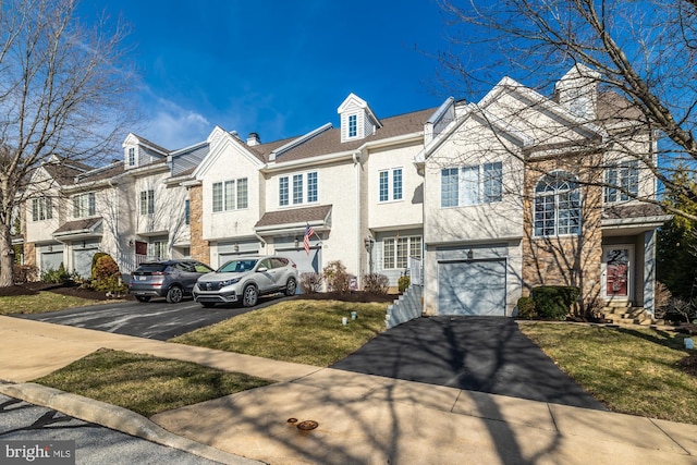 townhome / multi-family property with a residential view, driveway, a front yard, and a garage